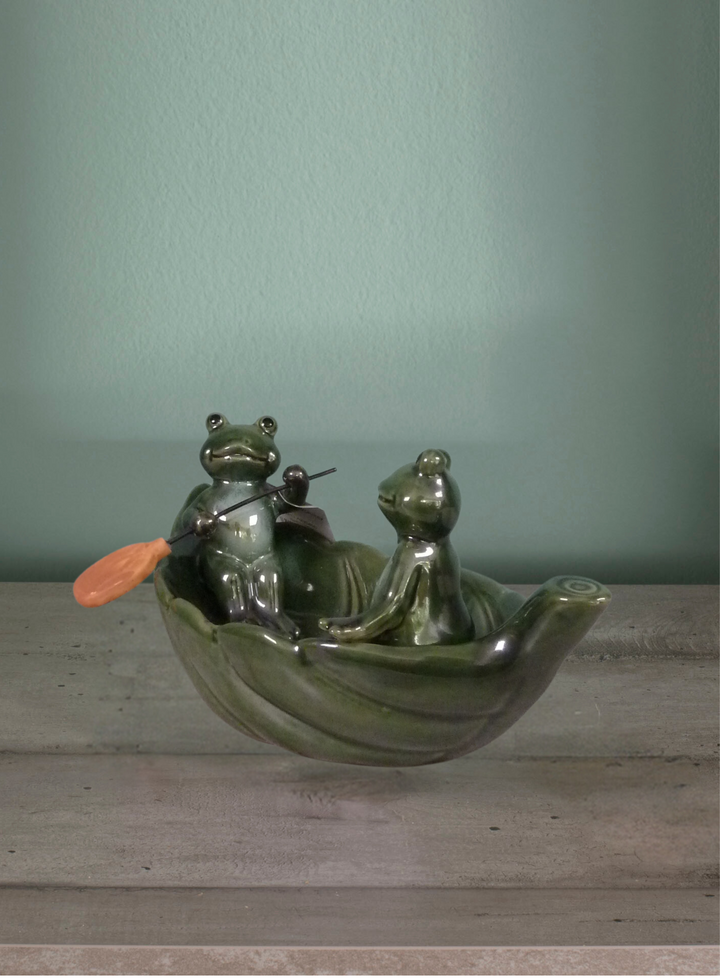 Elemento decorativo. Barchetta di foglia e due rane con remi. Verde. Ceramica. 27x15x13cm.