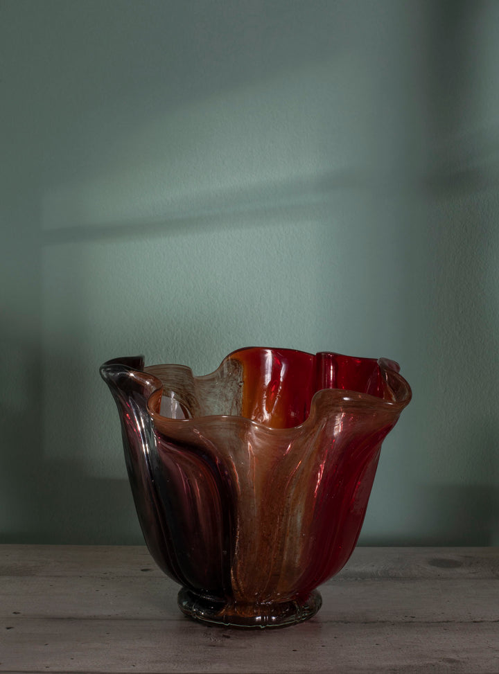 Vaso decorativo elegante con forma fluida e ondulata. Vetro traslucido. Colori caldi sfumati rosso ambrato, arancione e giallo. DIA 27 x H 21 cm