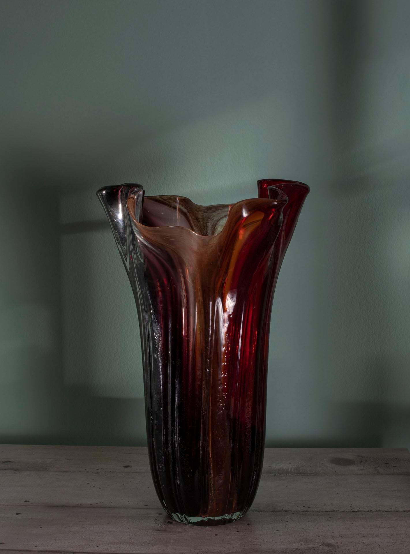 Vaso decorativo elegante con forma fluida e ondulata. Vetro traslucido. Colori caldi sfumati rosso ambrato, arancione e giallo. DIA 21,5 x H 37,5 cm